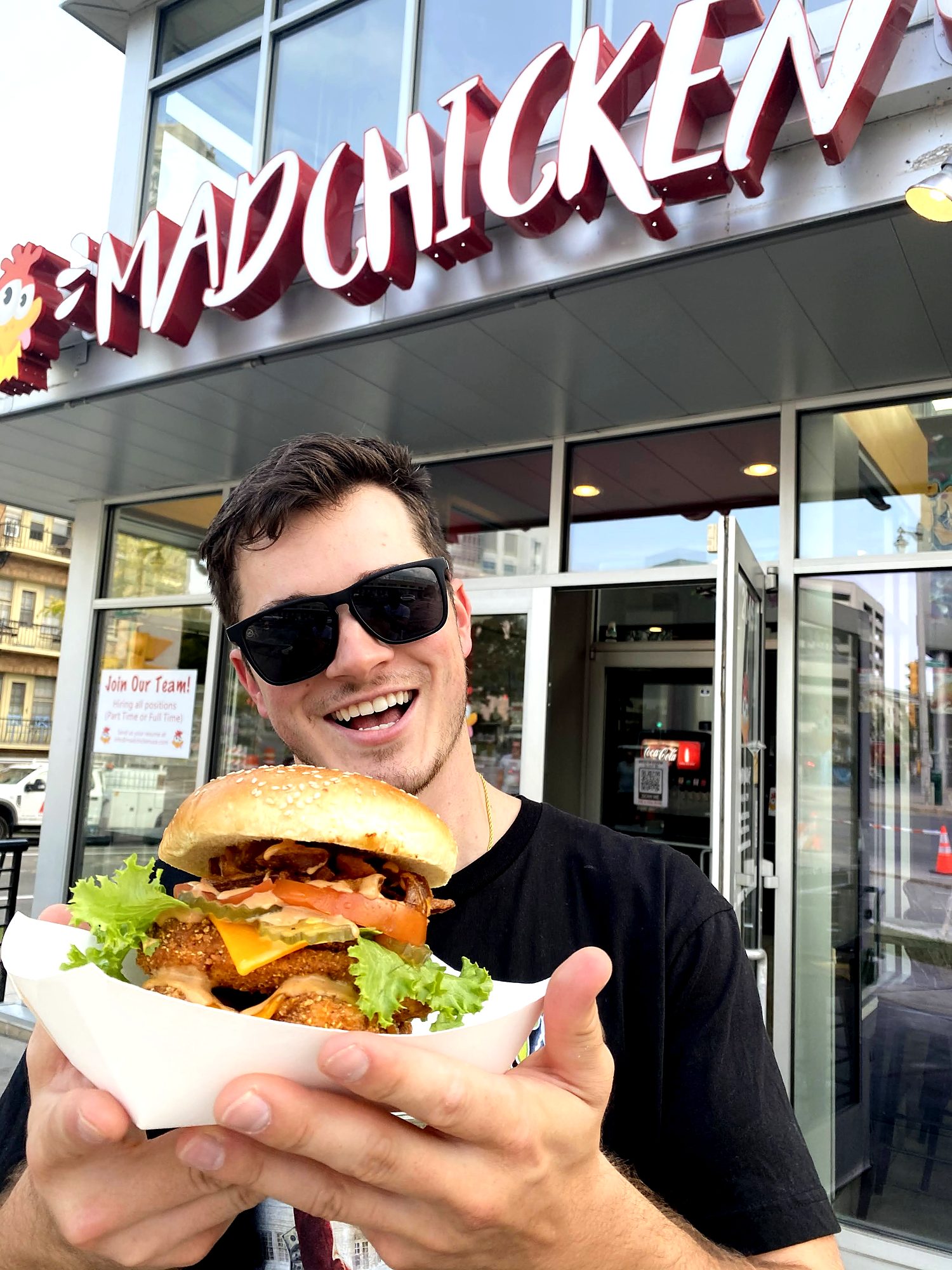 Guest with a sandwich outside a Mad Chicken